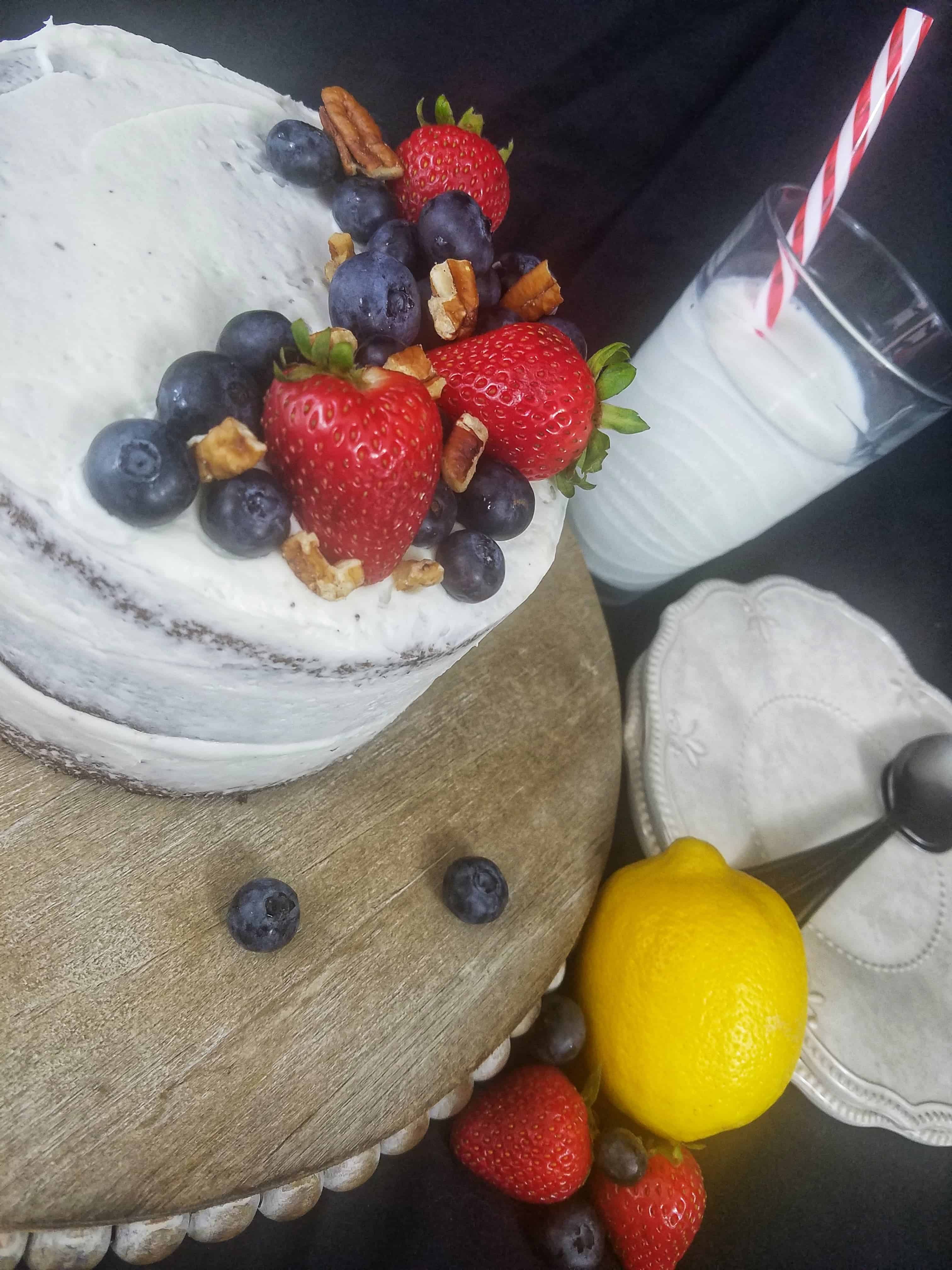 Gluten Free Chocolate cake topped with strawberries and blueberries glass of milk in background