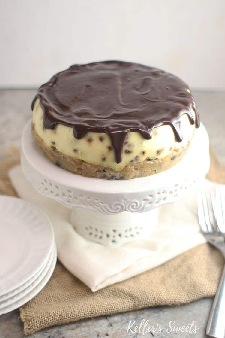 ganache dripping over edges of Instant Pot Chocolate Chip Cookie Dough Cheesecake on white cake stand