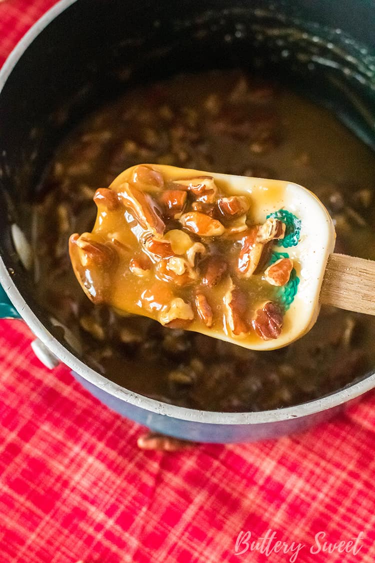 A spoon of caramel and pecan praline candy mix for Instant Pot Praline Cheesecake