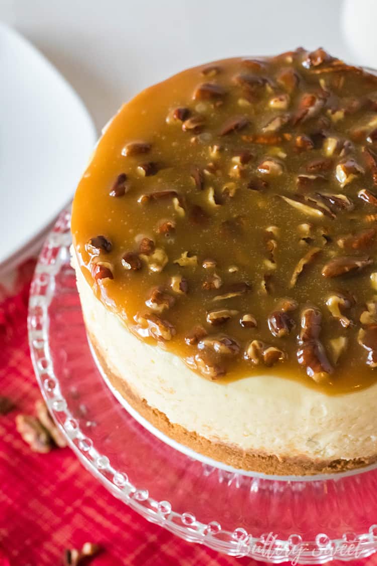 Instant Pot Praline Cheesecake on a cake plate with praline caramel topping