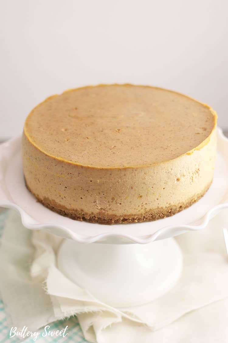 top view of Instant Pot Pumpkin Pie Cheesecake on a cake stand before caramel sauce