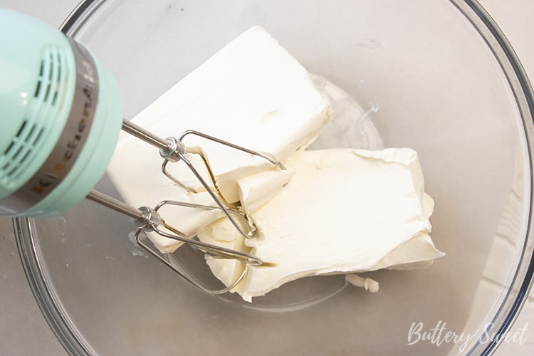 Blocks of cream cheese in a glass mixing bowl