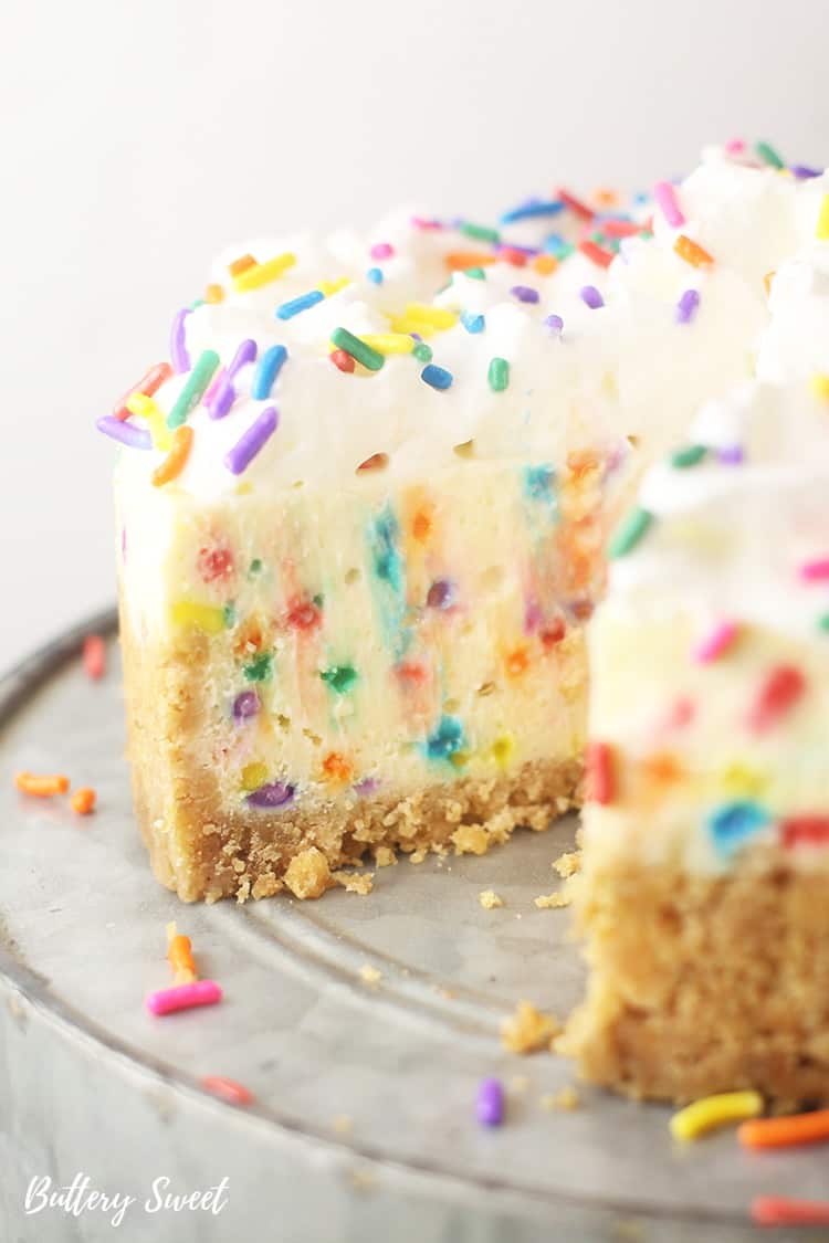 Funfetti cheesecake with a slice taken out showing the colorful inside