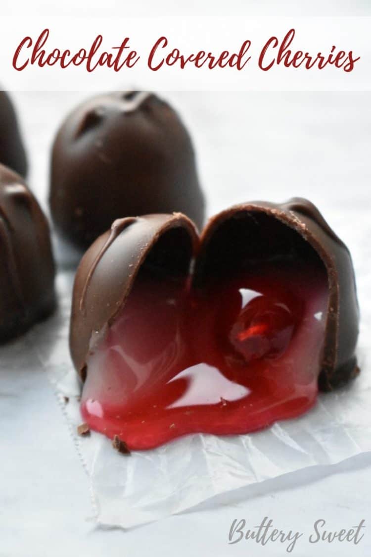 A chocolate covered cherry cut in two to show the gooey filling and cherry inside the chocolate shell.