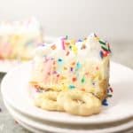 slice of funfetti cheesecake on a stack of white plates